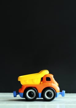 colorful plastic toy truck against the black background photo