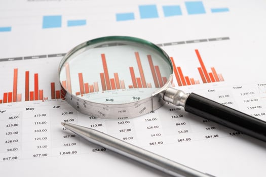 Magnifying glass on spreadsheet and graph paper. Financial development, Banking Account, Statistic, Investment Analytic research data economy, Business. photo
