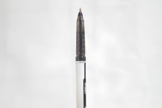 A pen with a black tip is sitting on a white background photo