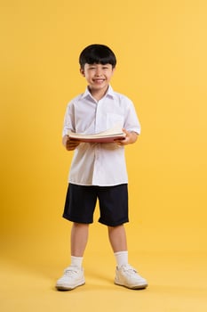 Portrait of adorable asian boy posing on yellow background photo