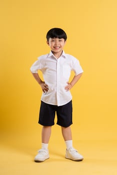 Portrait of adorable asian boy posing on yellow background photo