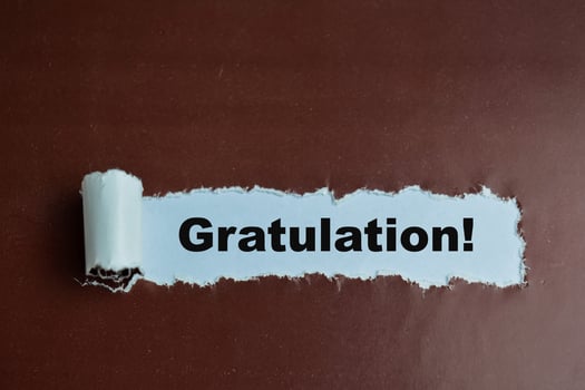 Concept of Learning language - German. Gratulation it means Congratulations written on torn paper. photo