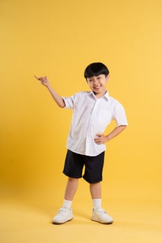 Portrait of adorable asian boy posing on yellow background photo