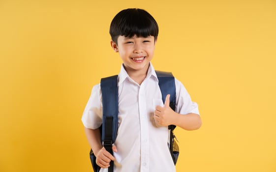 Portrait of adorable asian boy posing on yellow background photo