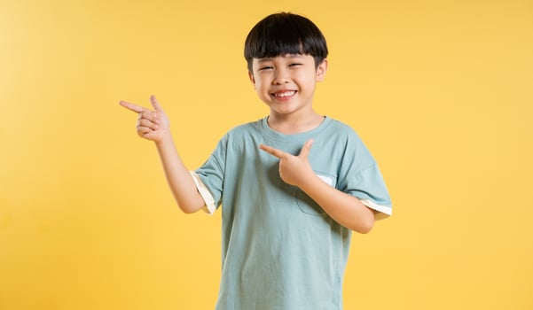 Portrait of adorable asian boy posing on yellow background photo