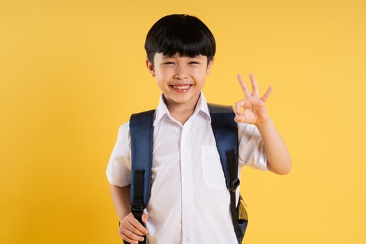 Portrait of adorable asian boy posing on yellow background photo