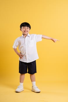Portrait of adorable asian boy posing on yellow background photo