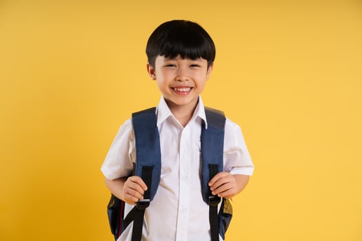 Portrait of adorable asian boy posing on yellow background photo