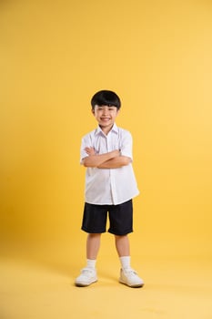 Portrait of adorable asian boy posing on yellow background photo