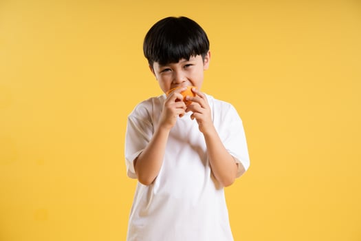 Portrait of adorable asian boy posing on yellow background photo