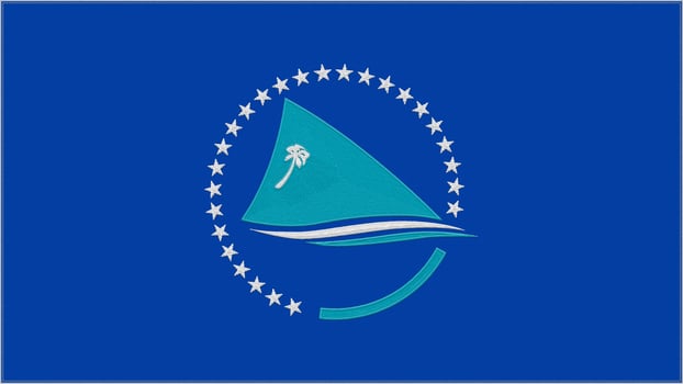 South Pacific Commission embroidery flag. Emblem stitched fabric. Embroidered coat of arms. Country symbol textile background. photo