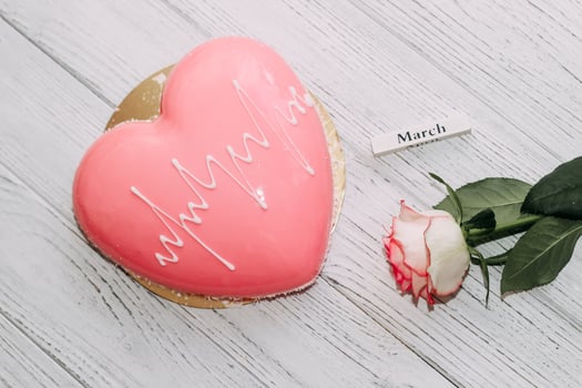Pink tea rose with heart shaped pink mousse cake and February 14 calendar. photo