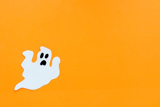 Paper ghosts on an orange background, Halloween concept photo