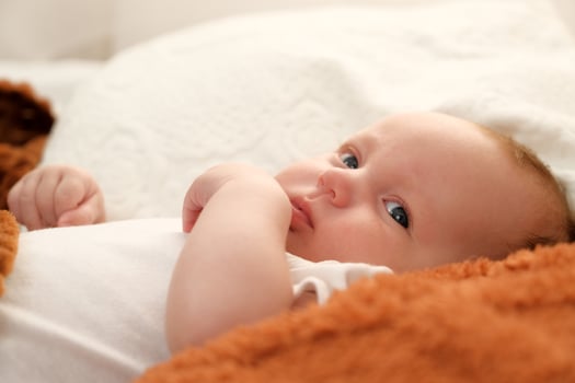 newborn baby lies on the bed. baby plays on the bed. photo
