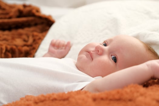 newborn baby lies on the bed. baby plays on the bed. photo