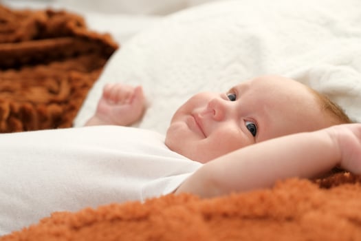 newborn baby lies on the bed. baby plays on the bed. photo