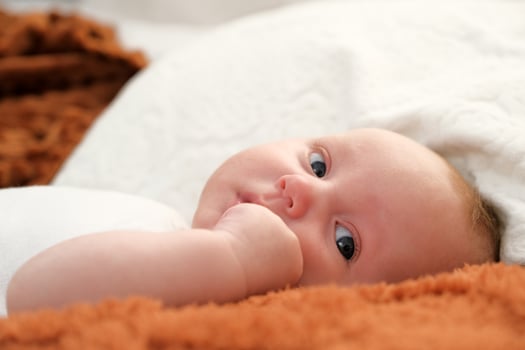 newborn baby lies on the bed. baby plays on the bed. photo