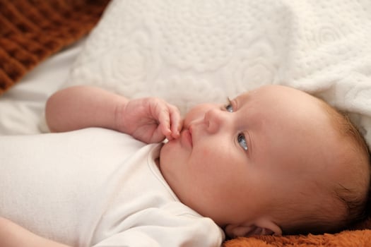 newborn baby lies on the bed. baby plays on the bed. photo