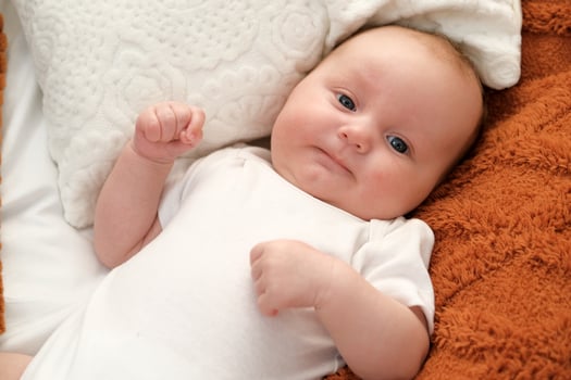 newborn baby lies on the bed. baby plays on the bed. photo