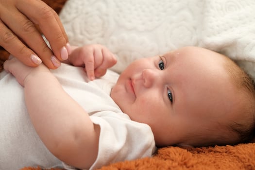newborn baby lies on the bed. baby plays on the bed. photo