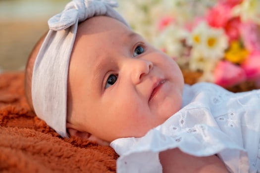 newborn baby girl lies on the beach. in a white dress. photo