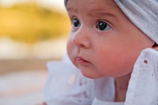 newborn baby girl lies on the beach. in a white dress. photo