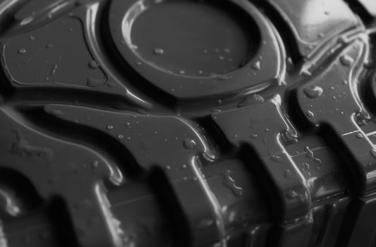Liquid drops on a black corrugated plastic detail. Stock photo for abstract plastic backgrounds