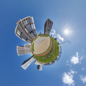 abstract swirling tiny planet spherical panorama of multi-storey buildings of skyscrapers of a residential complex in the form of a butterfly in blue sky photo