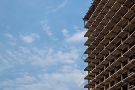 High-rise apartment building under construction against a blue sky with simple urban design photo