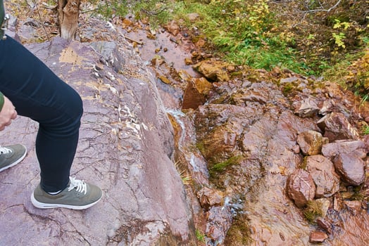 Female hiker walking in mountains forest. The woman found a beautiful stream in the mountains in the forest. photo