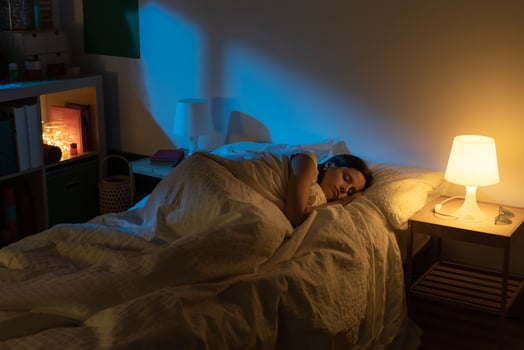 Beautiful girl suffering from insomnia lying in her bed with Blue Colors from the moon. photo