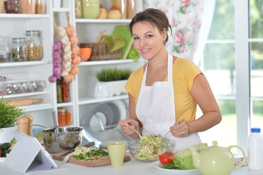 Portrait of beautiful young woman cooking dinner photo