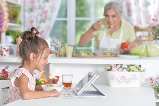 Portrait of young girl using tablet at kitchen photo