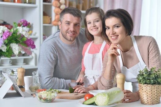 Portrait of young family cooking together at home photo