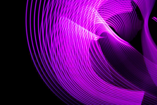 Abstract neon metallic purple curvy lines on black background. photo