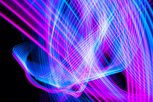 Abstract technology background of long exposure light. Blue and pink on black. photo