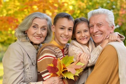 Portrait of grandparents spending time with grandchildren in park photo