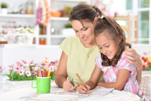Cute little girl with her mother doing homework photo
