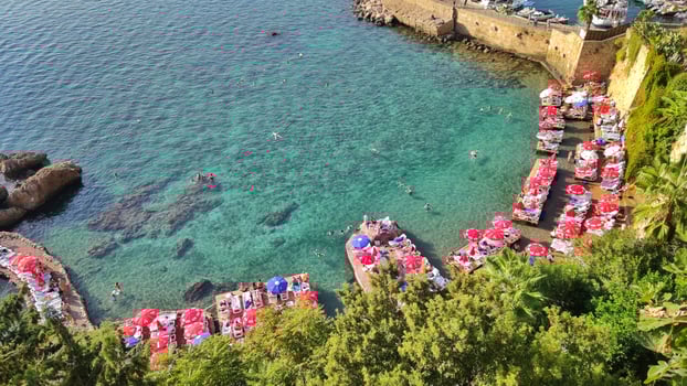 Turkey, Antalya, Kaleichi, October 23, 2023, people swim and sunbathe on well-maintained paid beach in beautiful blue lagoon, top view photo