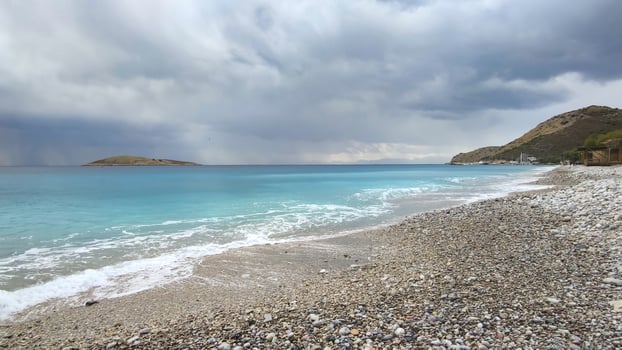 Panorama of sea coast, stormy sky over turquoise sea, view from shore. photo