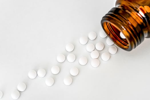 Medicine Close-Up, White Pills and Brown Vial Arranged on White Table, Close-Up, Flat Lay, Top View, Copy Space. photo