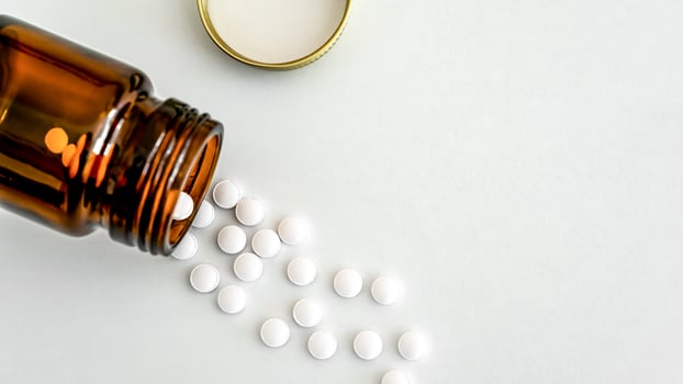 Medication Close-Up, White Pills and Brown Glass Vial Arranged on Table, Flat Lay, Copy Space, Close-Up, Healthcare Concept. photo