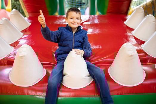 Happy boy having a lots of fun on a colorful inflate castle photo