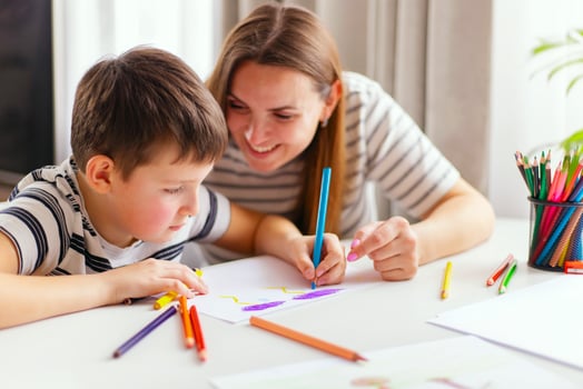 Mother and son drawing together with colorful pencils. photo