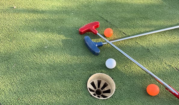 Golf ball and golf club on green in the evening golf course with sunshine photo