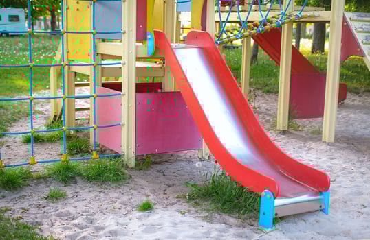 Children's playground with a red slide, perfect for outdoor recreation photo