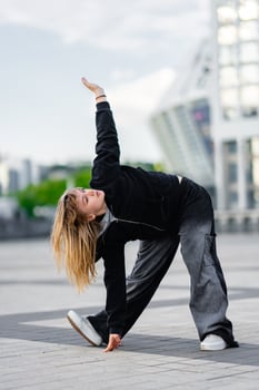 A young woman wears oversized clothes and dances hip-hop. photo