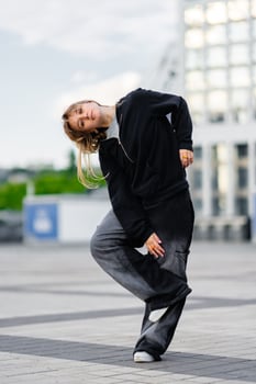 A young woman wears oversized clothes and dances hip-hop. photo