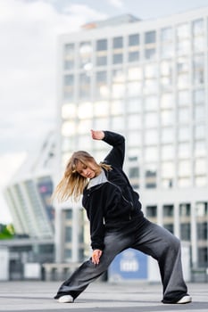 A young woman wears oversized clothes and dances hip-hop. photo