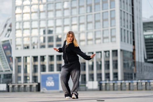 A young woman wears oversized clothes and dances hip-hop. photo